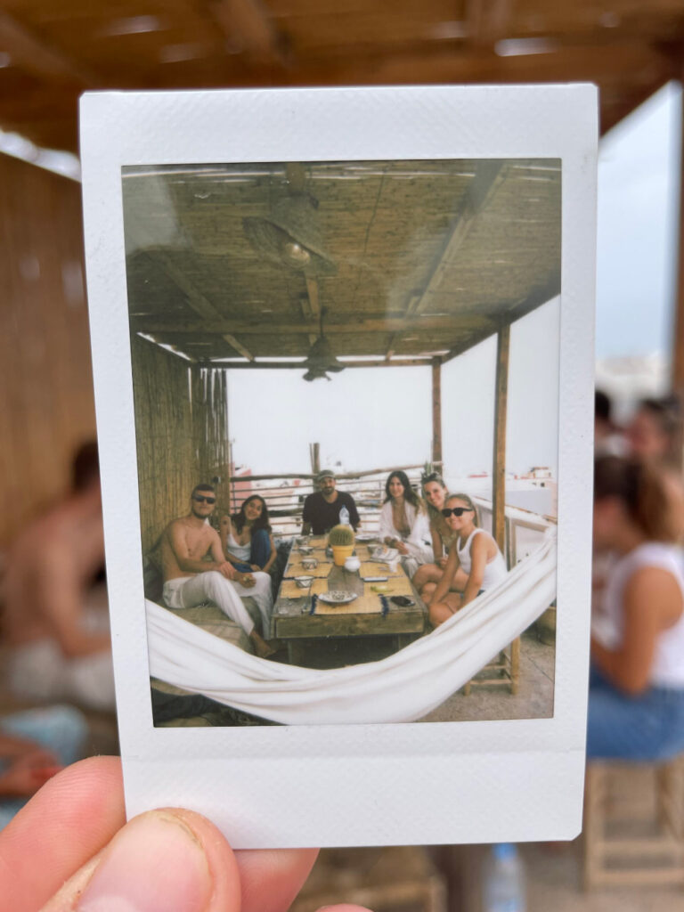 Polaroid photo of a group eating on the private rooftop at n'tona surf camp